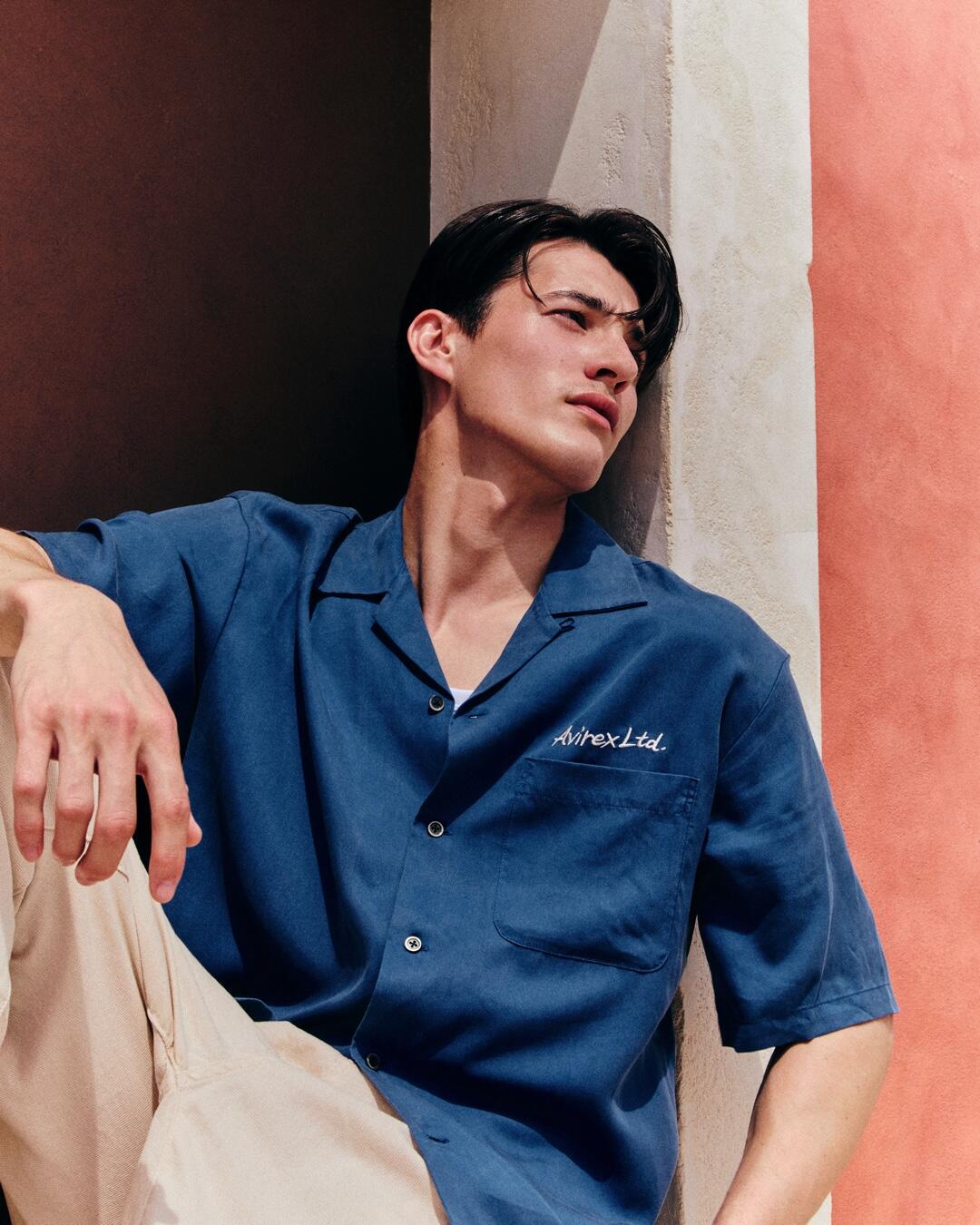 ネイビーのシャツと白のパンツを履いている男性