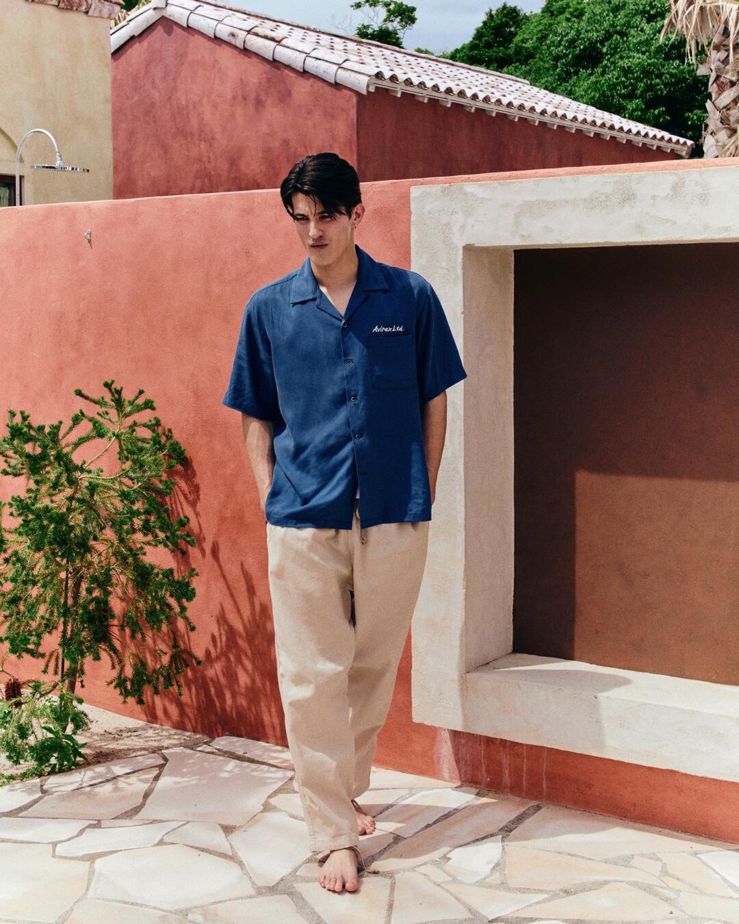 ネイビーのシャツと白のパンツを履いている男性